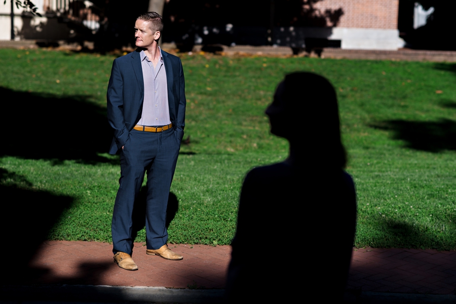 A man in full sun with his fiance in silhouette.